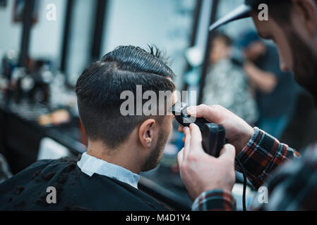Taglio Donna in barberia. Barbiere cesoie clippers. Soft focus. Foto Stock
