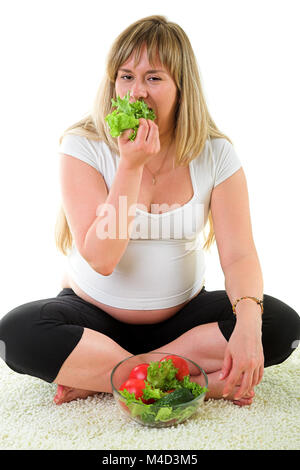 Donna incinta di mangiare le verdure Foto Stock