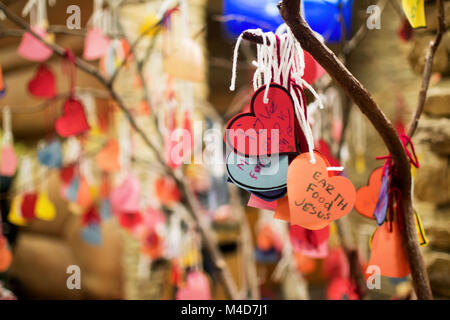 Cuori di carta realizzati dai bambini elencando le cose che amano legato ad un albero con cordino bianco. Foto Stock