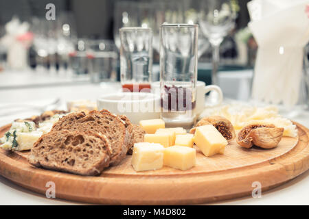 Diversi e deliziosi formaggi sulla rotonda di legno board Foto Stock