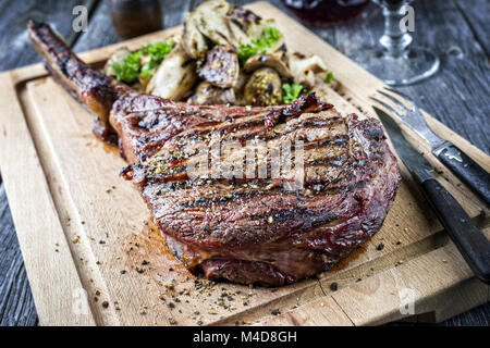 Barbecue Tomahawk Steak sul bordo di taglio Foto Stock