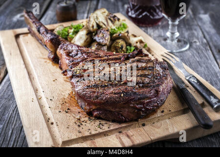 Barbecue Tomahawk Steak sul bordo di taglio Foto Stock