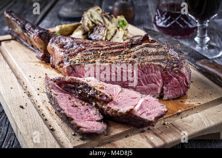 Barbecue Tomahawk Steak sul bordo di taglio Foto Stock