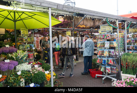 I turisti e la gente del posto lo shopping al famoso mercato dei fiori di Amsterdam, Paesi Bassi per fiori e negozio di souvenir. Coperto di stallo di fiori. Foto Stock