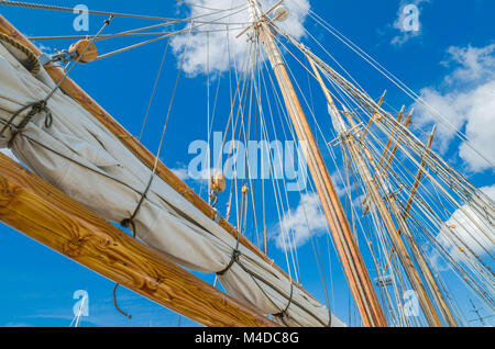 Vela ripiegata e montante su una vecchia barca a vela Foto Stock