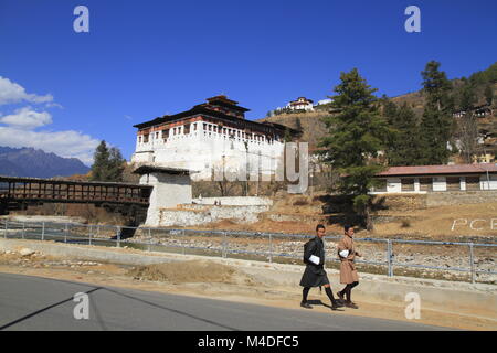 Bhutanese di giovane uomo in abiti tradizionali a piedi sulla strada Foto Stock