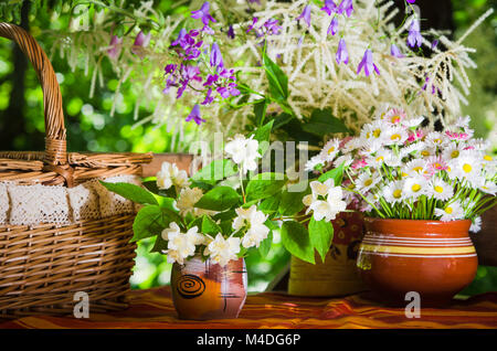 Panini in un cesto di vimini e un mazzo di fiori Foto Stock