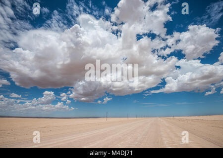 Immagine vibrante della strada nel deserto e blu cielo nuvoloso Foto Stock