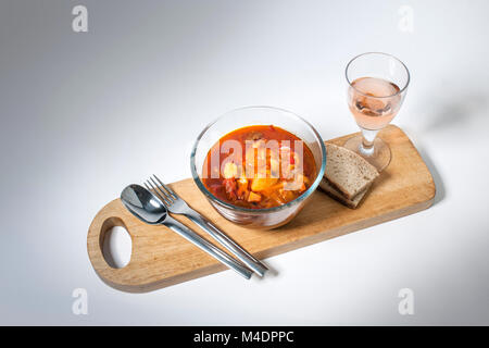 Gulasch servito con pane e vino rosato Foto Stock