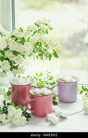 Cioccolata calda con marshmallows in rosa tazze Foto Stock