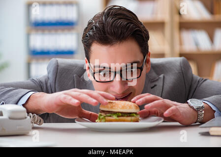 Fame funny imprenditore di mangiare cibo spazzatura sandwich Foto Stock