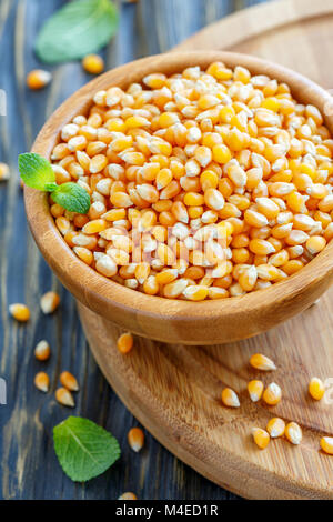 Ciotola di legno con mais per popcorn. Foto Stock