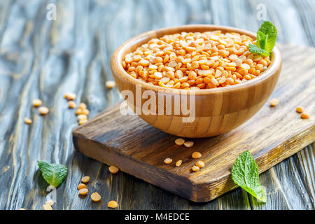 Asciugare piselli gialli in una ciotola di legno. Foto Stock