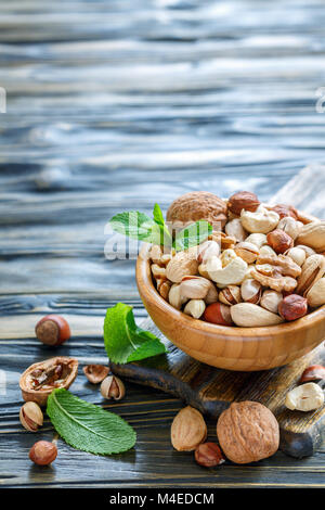 Un assortimento di dadi in una ciotola di legno. Foto Stock