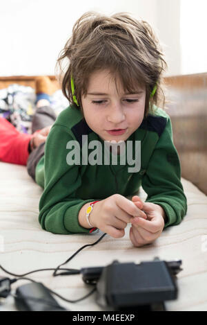 Ragazzo disteso sul suo letto i giochi per computer Foto Stock