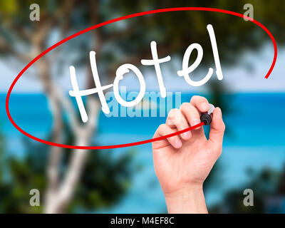 Man mano che scrive Hotel con pennarello nero su schermo visivo Foto Stock