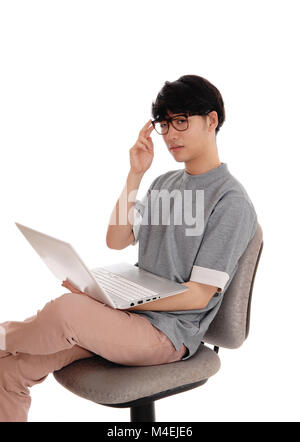 Uomo asiatico a lavorare al suo computer portatile. Foto Stock