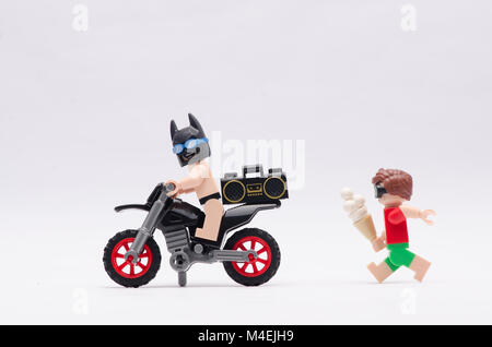 Minifigure LEGO Batman in sella a una dirt bike con robin inseguono lui. isolato su sfondo bianco. Foto Stock