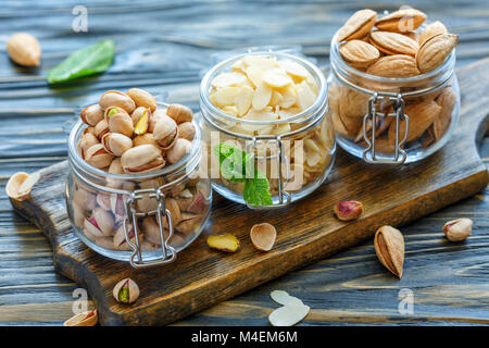 Pistacchi, mandorle e scaglie di mandorle in una ciotola di vetro. Foto Stock