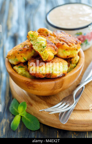 Frittelle fritte di zucchine in una ciotola di legno. Foto Stock