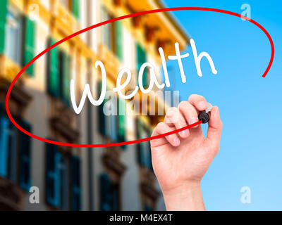 Man mano la ricchezza di scrittura con pennarello nero su schermo visivo Foto Stock