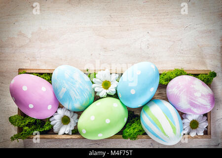 Decorazione di Pasqua - uova e fiori su legno Foto Stock