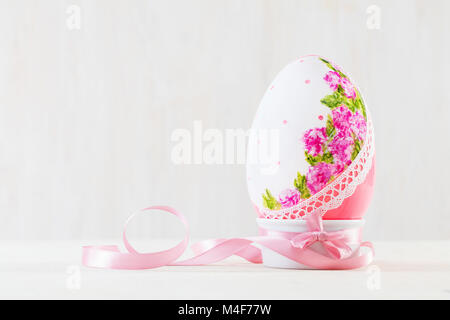 Singolo uovo di pasqua su un tavolo di legno. Decoupage tecnica Foto Stock