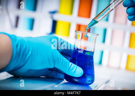 Scienziato prende il campione di liquido chimico. Foto Stock