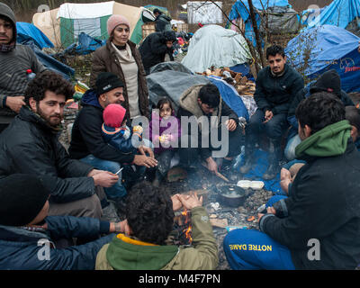 Grande-Synthe, nel nord della Francia. Il 31 gennaio 2016. Il Grande-Synthe Refugee Camp vicino al porto di Dunkerque in Francia settentrionale. Nel campo condizioni sono grim in parte a causa di fango spesso e la mancanza di servizi di base. Le famiglie vivono in imbevuto tende e stringersi intorno a piccoli incendi per il calore base. Foto Stock