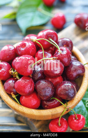 Ciotola con ciliege rosse in acqua cade closeup. Foto Stock