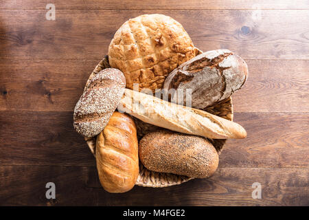 Angolo di Alta Vista di una varietà di pane appena sfornato nel cesto di vimini Foto Stock