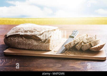 Fette di pane sul tagliere con un coltello a scrivania in legno Foto Stock