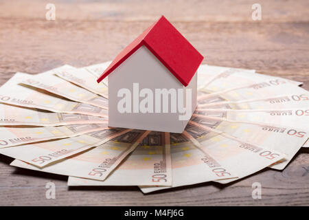 Elevato angolo di visione di un modello di casa sulle banconote in euro Foto Stock