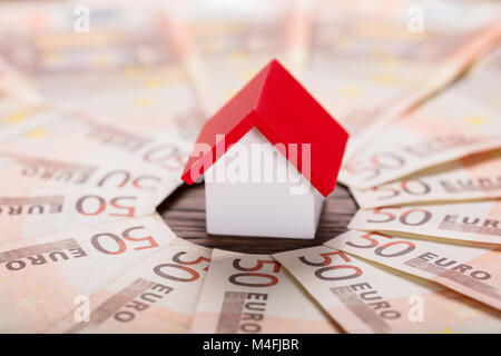 Elevato angolo di visione di un modello di casa sulle banconote in euro Foto Stock