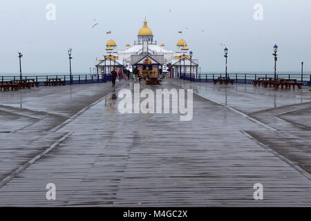 Il deck e edifici di Eastbourne Pier sul bagnato un giorno di pioggia Foto Stock