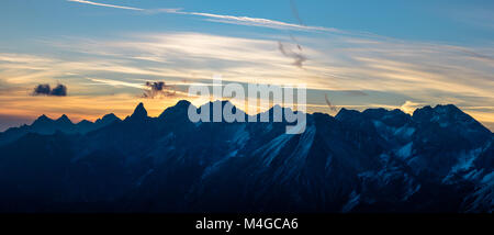 Spettacolari blue mountain range sagome e sunrise orange nuvole Foto Stock
