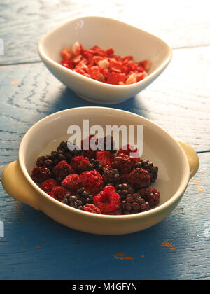 Organico essiccato di frutti in ciotole in legno di colore bluastro tavolo da cucina Foto Stock