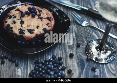 Torta ai mirtilli in piastra nera sul tavolo di legno Foto Stock