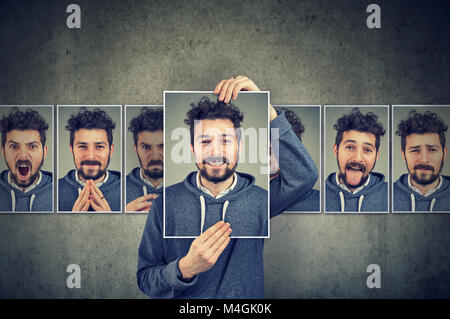 Mascherato positivo giovane uomo in bicchieri esprimendo emozioni diverse Foto Stock