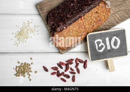 Bio senza glutine proteina bar con ingredienti e copyspace segno su un tavolo di legno. Foto Stock