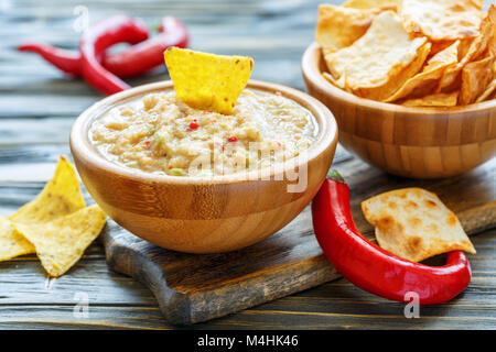 Guacamole in una ciotola di legno e con tortilla chips. Foto Stock