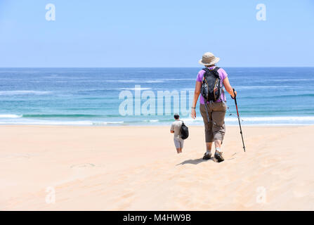 Una femmina di escursionisti a piedi con un cappello, un sacchetto e trekking pole sulla spiaggia di Robberg vicino a Plettenberg Bay in Sud Africa con la spiaggia e la Indian Oc Foto Stock