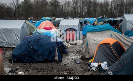 Grande-Synthe, nel nord della Francia. Il 31 gennaio 2016. Una vista generale della Grande-Synthe Refugee Camp vicino al porto di Dunkerque in Francia settentrionale. Nel campo condizioni sono grim in parte a causa di fango spesso e la mancanza di servizi di base. Le famiglie vivono in pioggia inzuppato tende e stringersi intorno a piccoli incendi per il calore base. Foto Stock