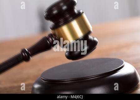 Close-up di un martello a riscontro sulla scrivania di legno in un aula di un tribunale Foto Stock