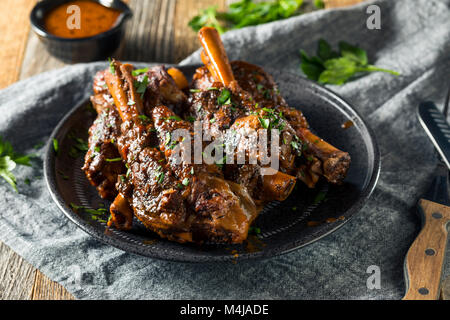 In casa il brasato di gambi di agnello con salsa di pomodoro e le erbe aromatiche Foto Stock