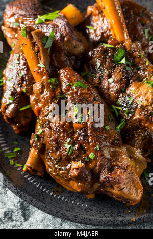 In casa il brasato di gambi di agnello con salsa di pomodoro e le erbe aromatiche Foto Stock