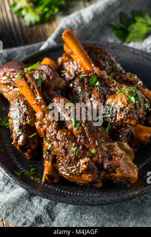 In casa il brasato di gambi di agnello con salsa di pomodoro e le erbe aromatiche Foto Stock