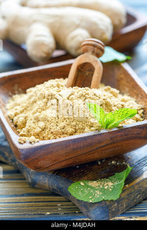 Lo zenzero in polvere in un recipiente di legno. Foto Stock