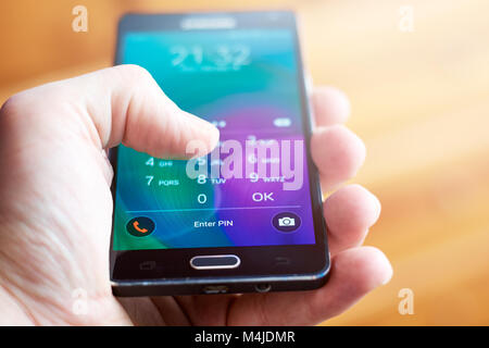 BUENOS AIRES, Argentina - 15 febbraio 2018: una persona in possesso di un telefono cellulare e inserendo il codice di sicurezza (PIN) per sbloccarlo. Focus su 'Immettere PIN'. Foto Stock