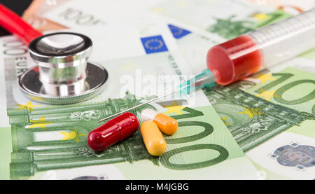 Centinaia di euro le fatture o le banconote con le pillole siringa e uno stetoscopio come Europa assicurazione medica nozione Foto Stock